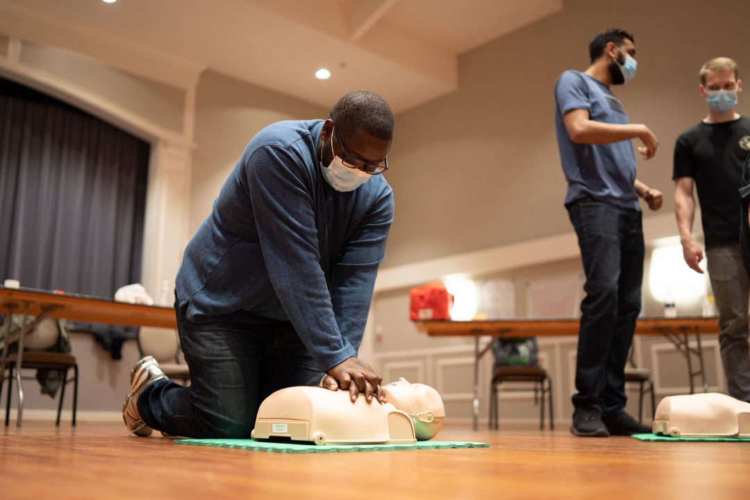 Students practicing infant CPR under the guidance of Pacific First Aid trainers